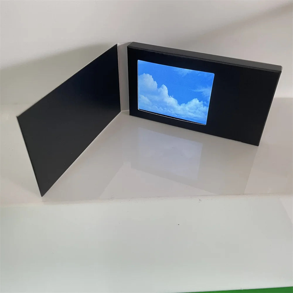 Black electronic device displaying a blue screen with cloud imagery on a white background