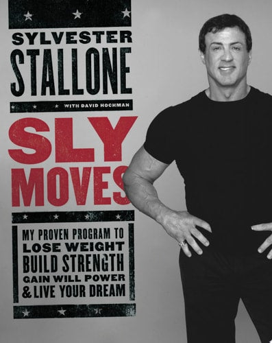 Person standing next to a book titled 'Sly Moves' by Sylvester Stallone