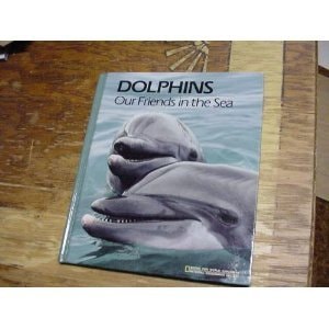 Book titled 'Dolphins: Our Friends in the Sea' on a wooden surface