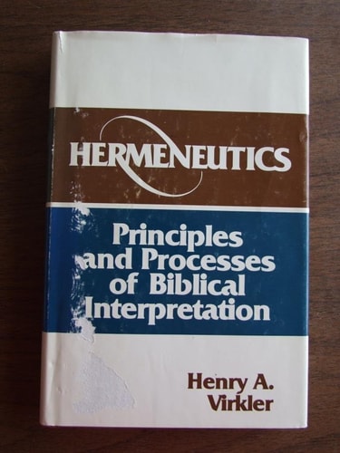 Book titled 'Hermeneutics: Principles and Processes of Biblical Interpretation' by Henry A. Virkler on a wooden surface.