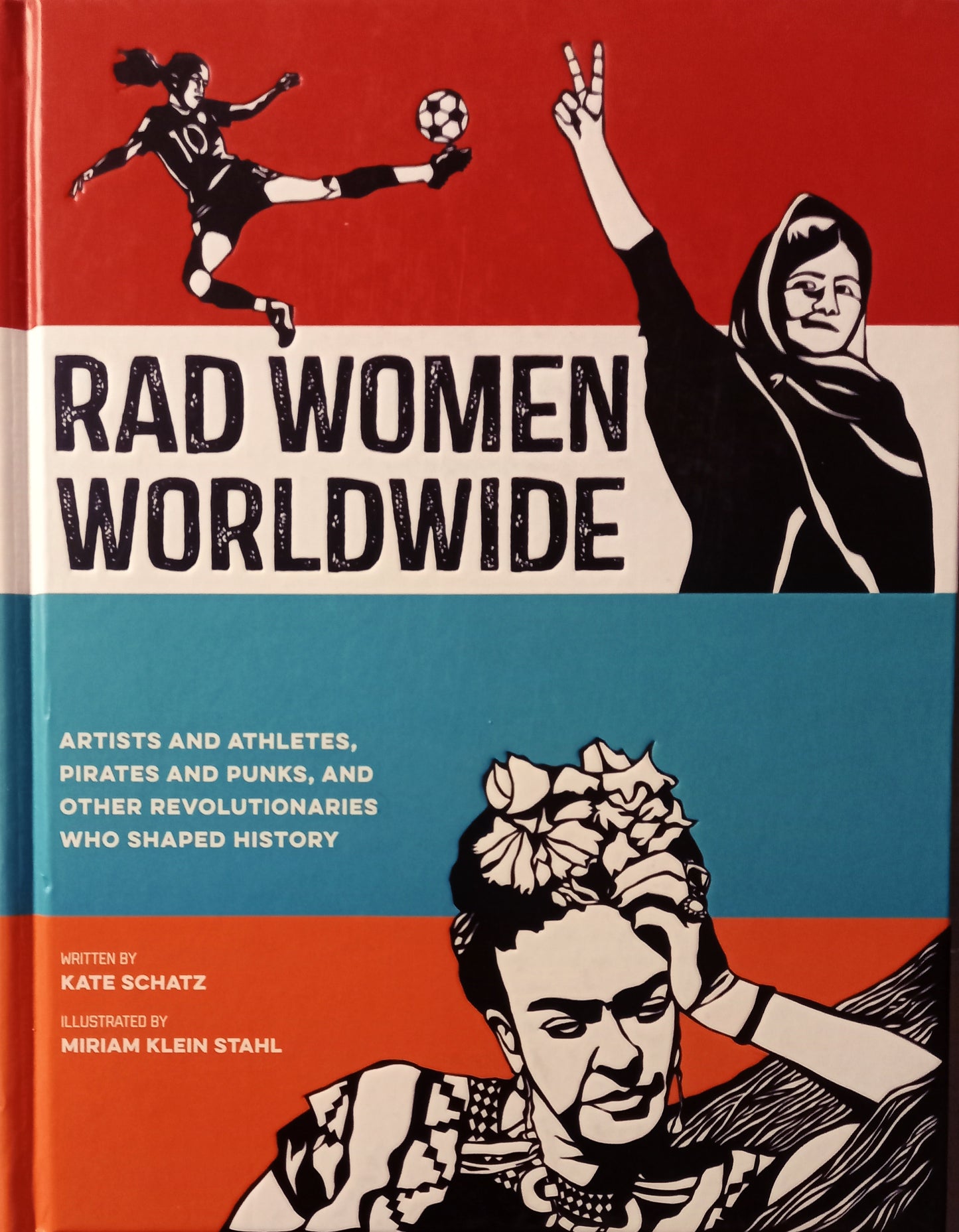 The cover of the book "Rad Women Worldwide" features a cartoon illustration of a woman with a soccer ball, alongside a line art portrait of a woman with a floral headdress. The background is split into horizontal bands of red, white, and orange.