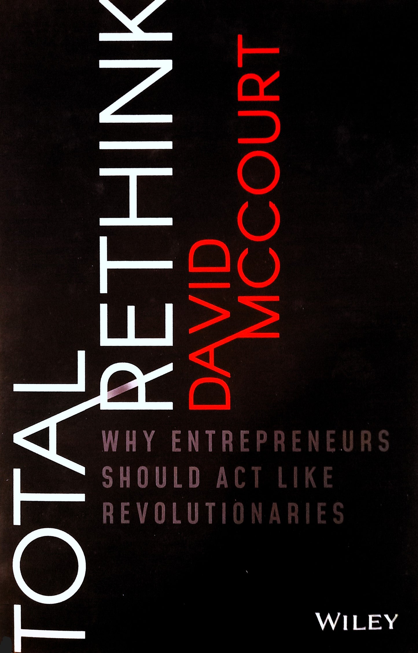 This image features the cover of the book "Total Rethink" by David McCourt. The cover design is sleek and modern, with a dark background and prominent white and red text that highlights the title and the author's name.