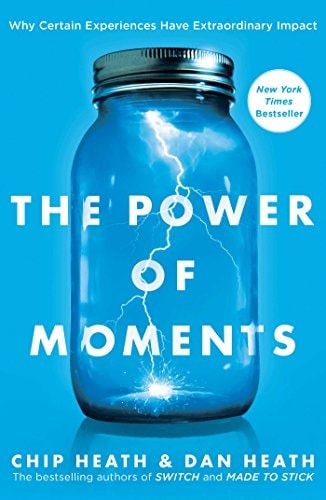 The cover of the book 'The Power of Moments' featuring a glass jar with a lightning bolt inside, set against a blue background.
