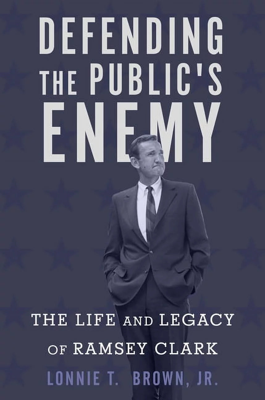 Book front cover of "Defending the Public's Enemy: The Life and Legacy of Ramsey Clark (ISBN: 9781503601390)" by Lonnie T. Brown, Jr., featuring the author posing in a suit and tie, looking off into the distance.