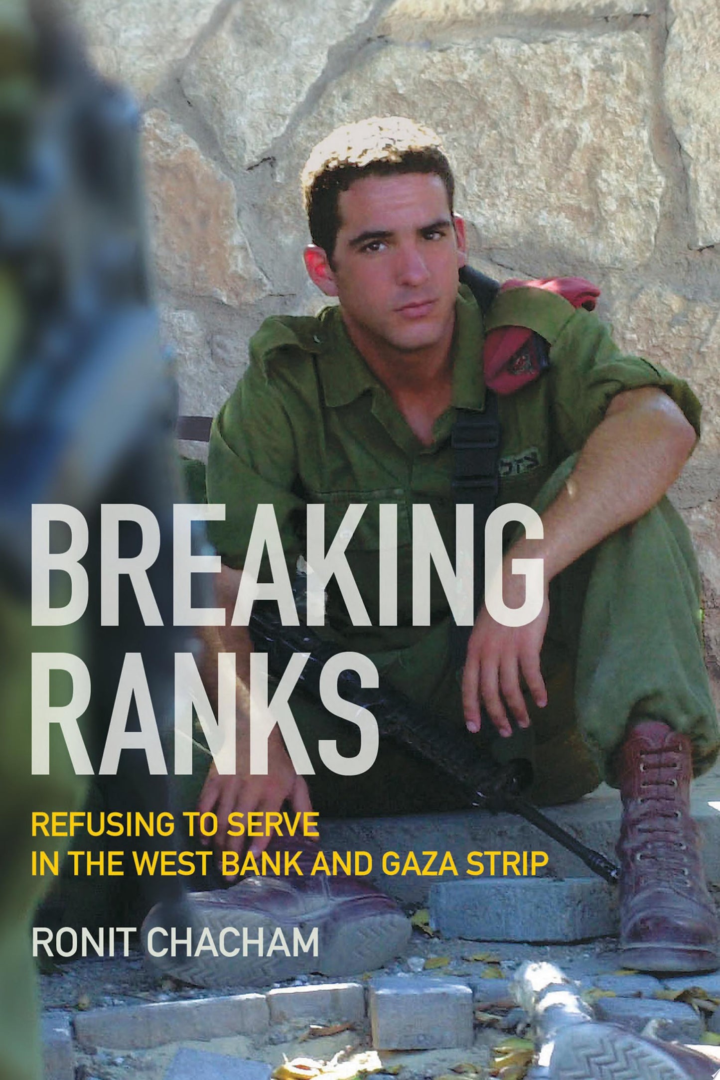 Book cover for 'Breaking Ranks: Refusing to Serve in the West Bank and Gaza Strip' by Ronit Chacham, featuring a soldier in olive green sitting against a stone wall with large white title text.
