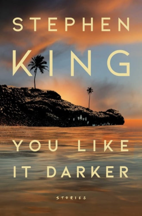 The cover of the book 'You Like It Darker: Stories' by Stephen King features a body of water with a palm tree in the background, under a sky with a sunset.