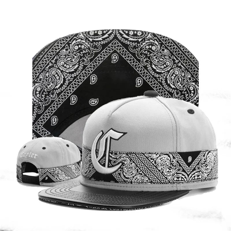 Two caps with bandana patterns on a white background