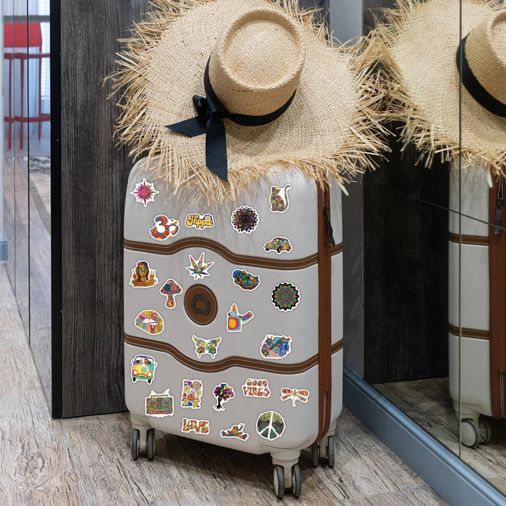 Suitcase with colorful stickers and a straw hat on top, leaning against a glass door.