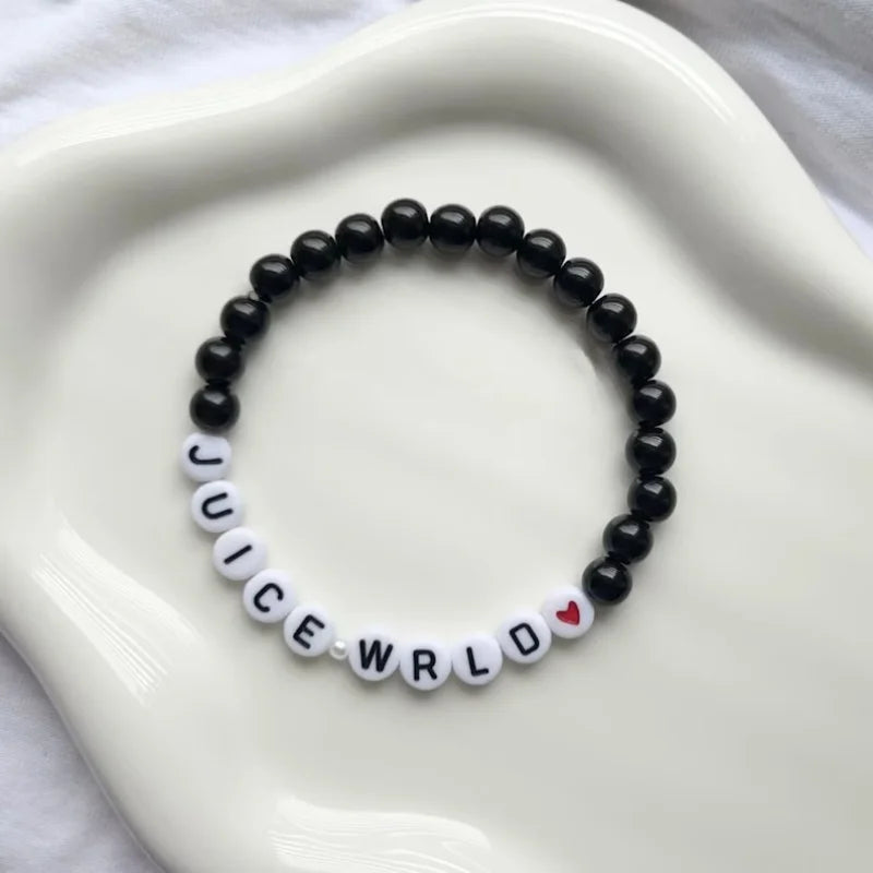 Black beaded bracelet with 'Juice WRLD' on a white dish