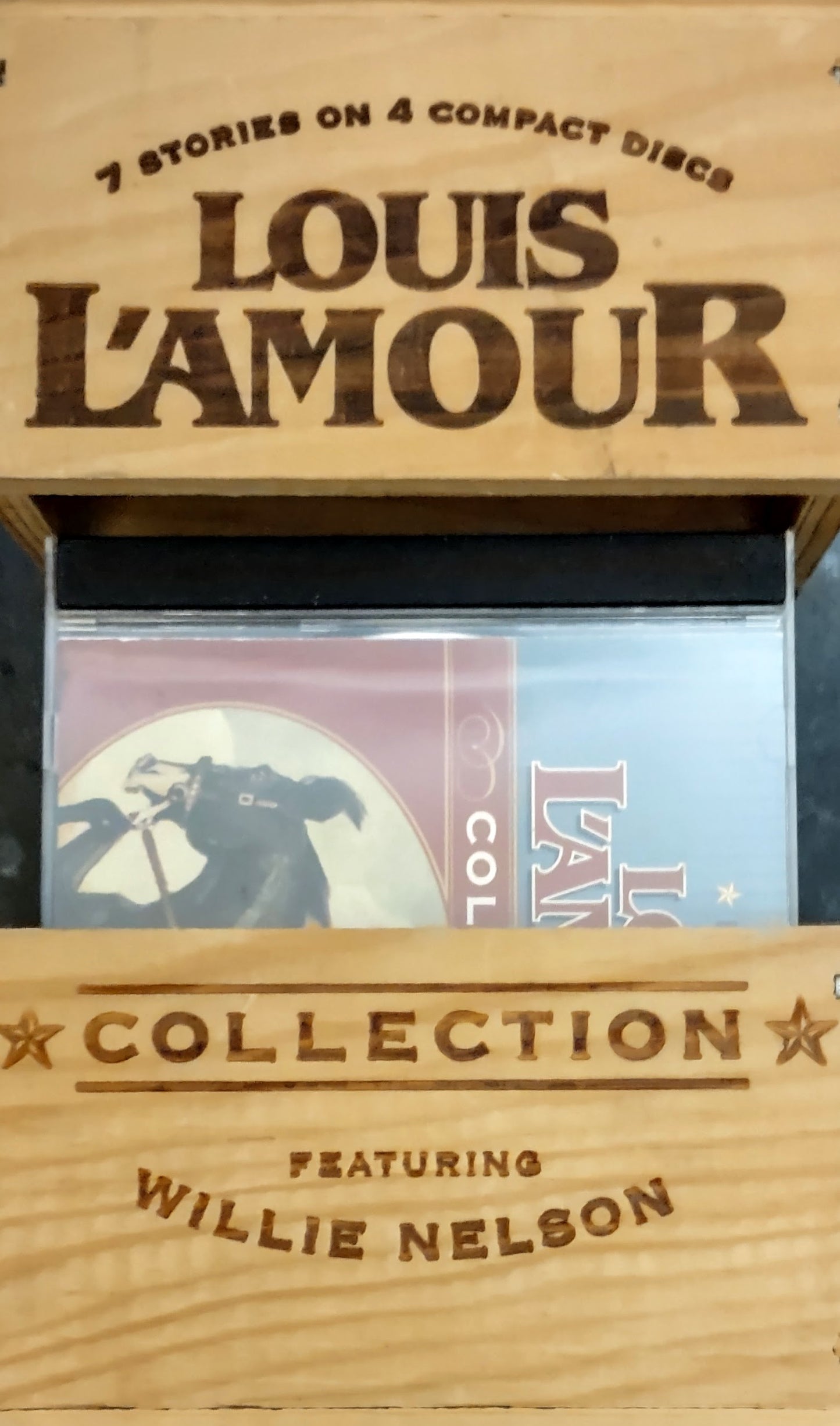 Wooden box containing 'Louis L'Amour' and 'Willie Nelson' collections on compact discs.
