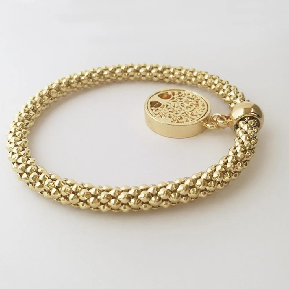 A gold-colored bracelet featuring a circular pendant with the Polish flag colors and the Polish eagle emblem. mage displaying back of bracelet laid flat on white surface