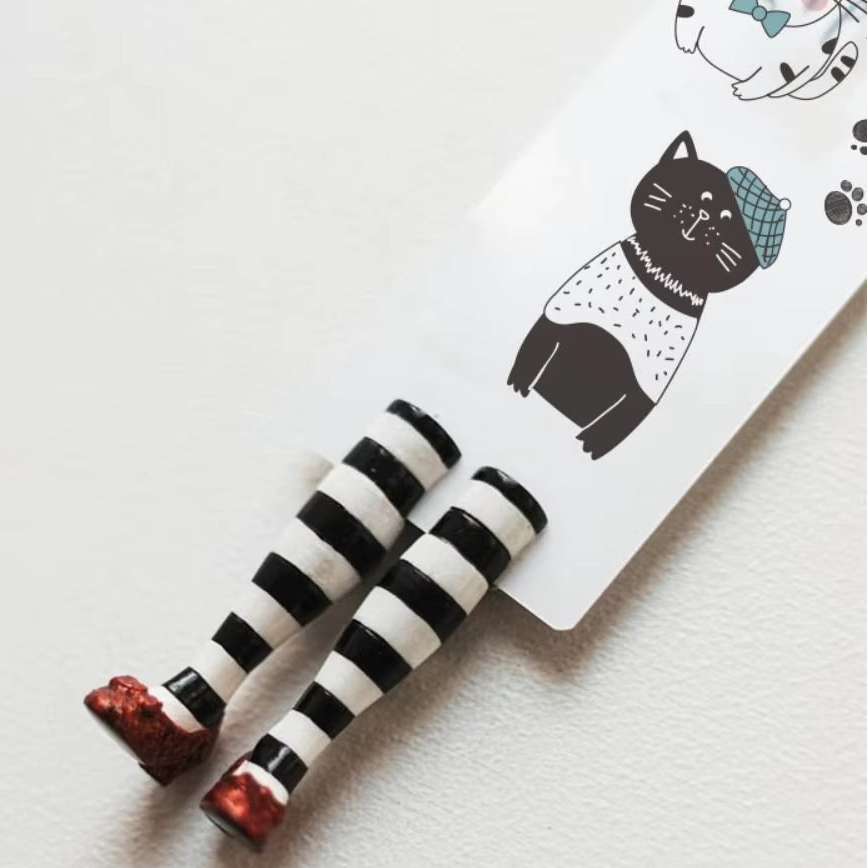 Red slippers bookmark attached to a paper insert with a beret wearing cat.