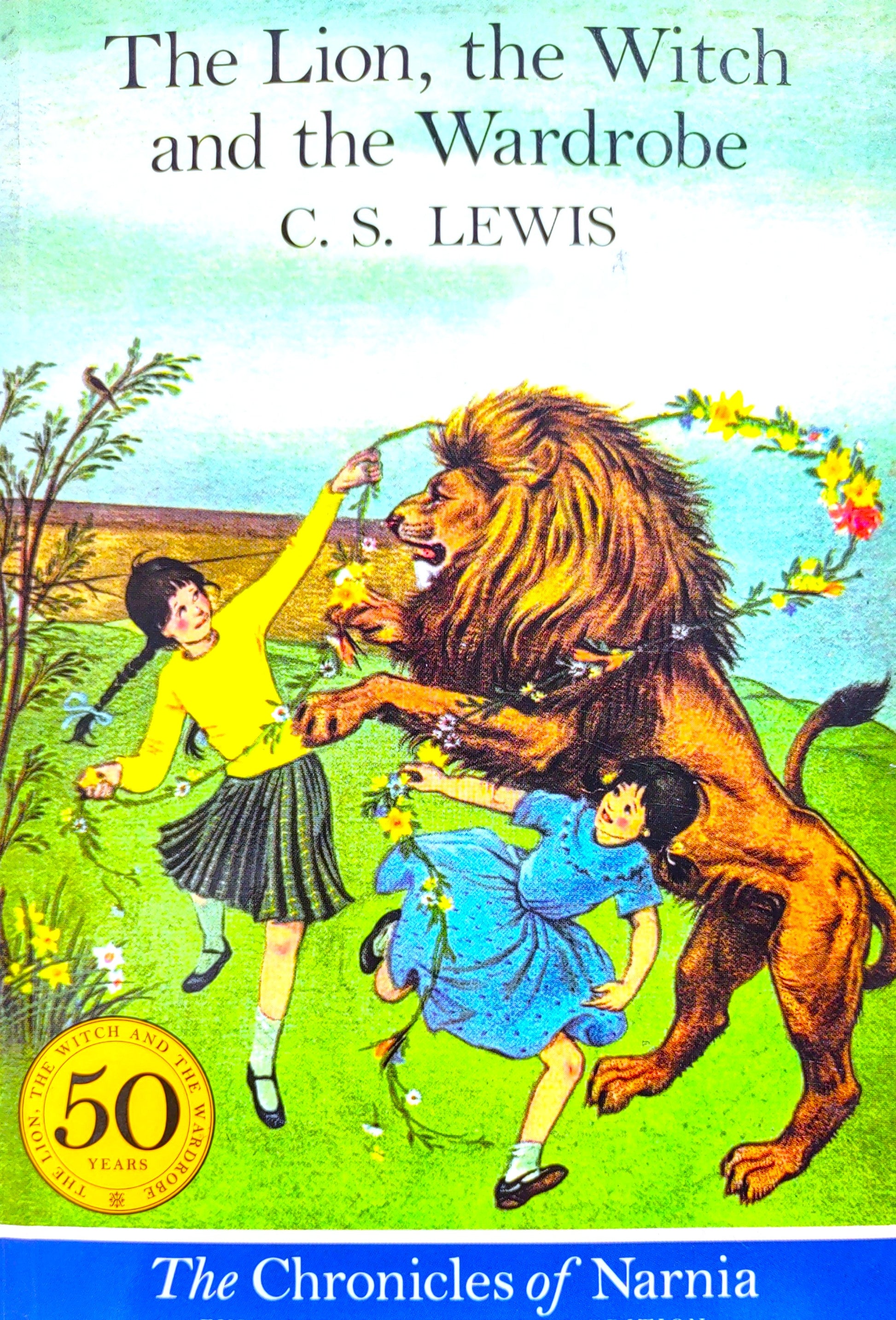 Book cover of 'The Lion, the Witch and the Wardrobe' by C.S. Lewis featuring a lion, two children, and a colorful background.