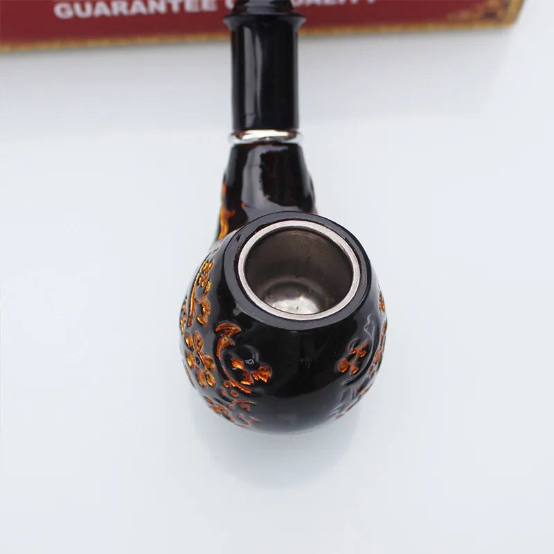 Black smoking pipe with decorative patterns on a white background