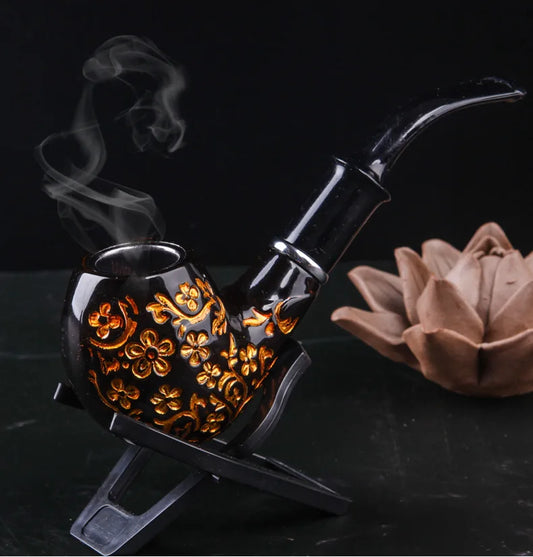 Decorative smoking pipe with intricate designs on a dark background