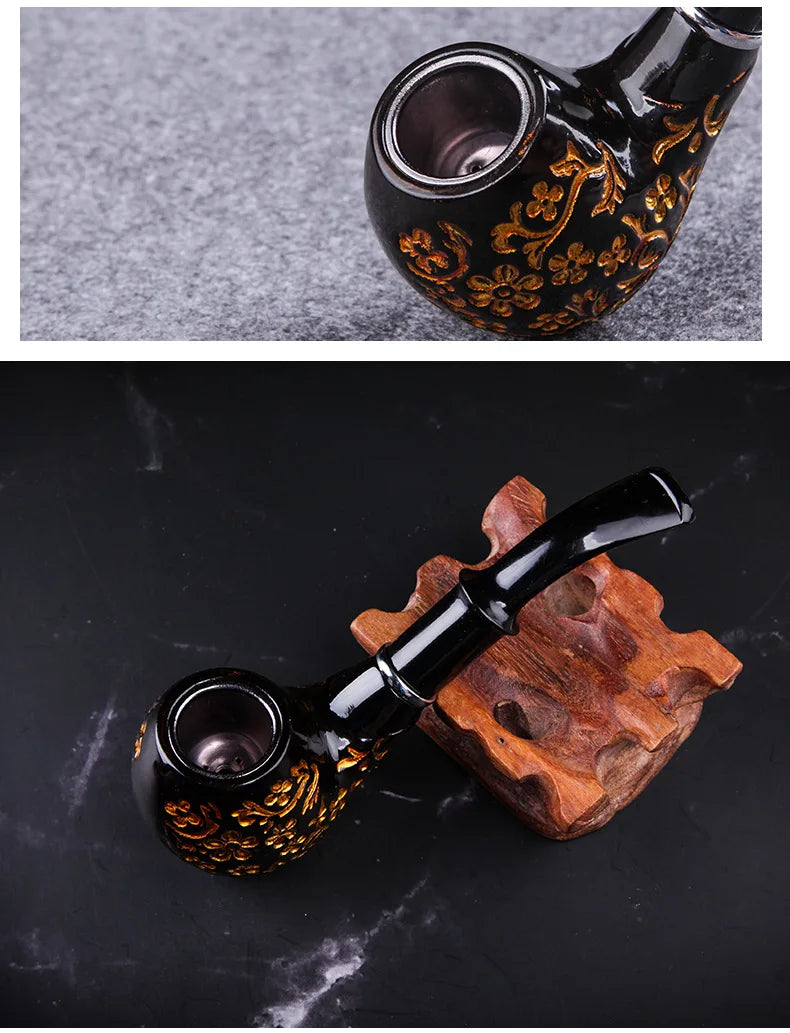 Black smoking pipe with decorative patterns on a textured surface