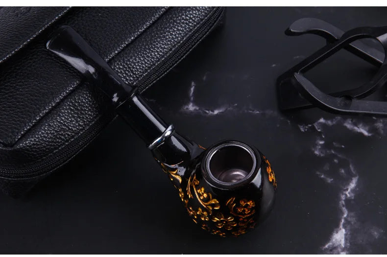 Decorative smoking pipe with intricate design on a dark surface