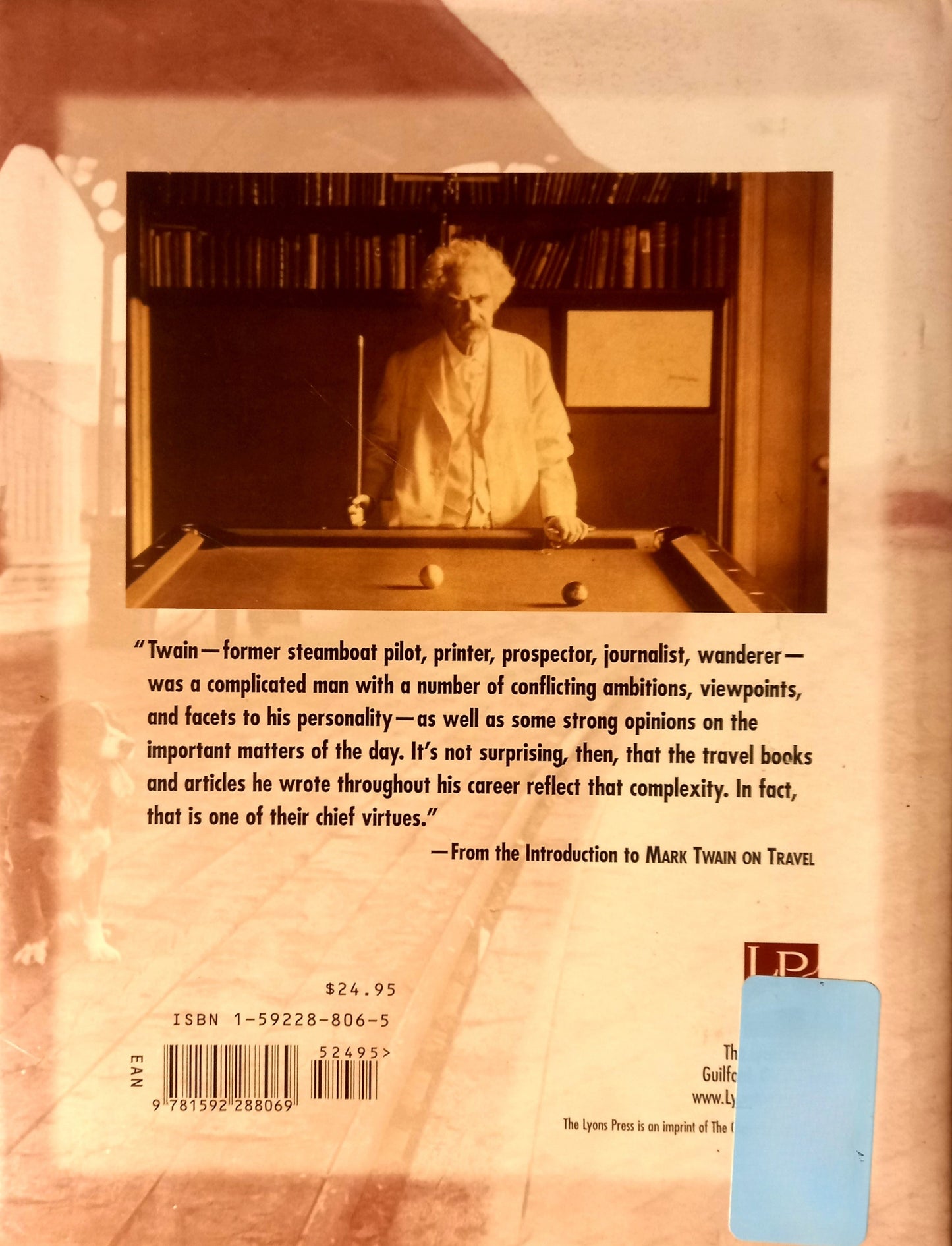 Book back cover of "Mark Twain on Travel" by Mark Twain and Edited by Terry A. Mort. Featuring a centered portrait of Twain standing over a pool table with a pool stick in hand with the synopsis, barcode and ISBN number below.
