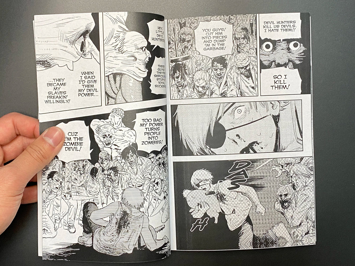 Comic book open to a page with black and white illustrations and text.