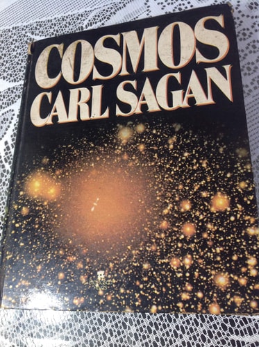 Book cover of 'Cosmos' by Carl Sagan with a cosmic background