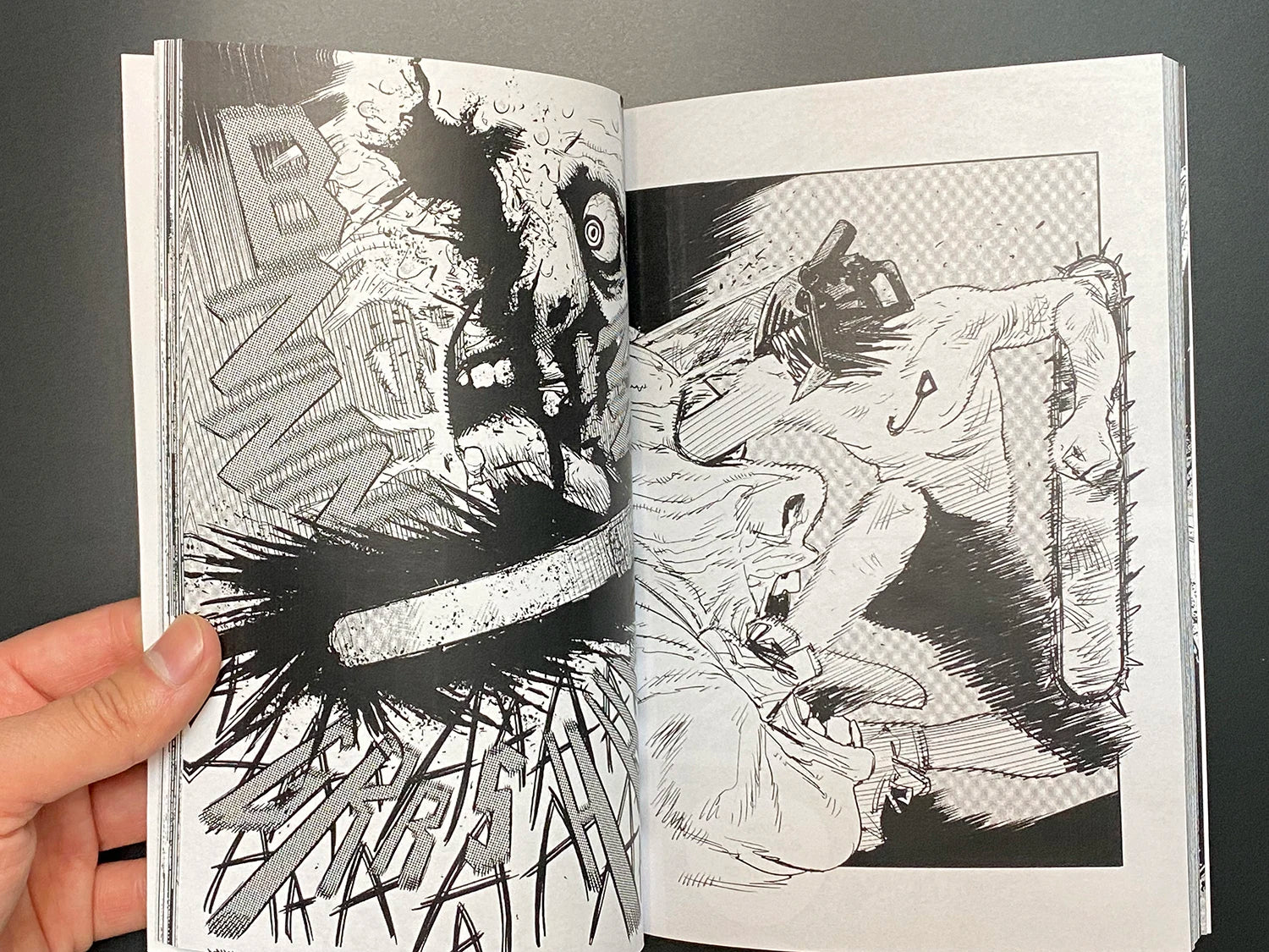Open book displaying black and white comic book art with a person being attacked.