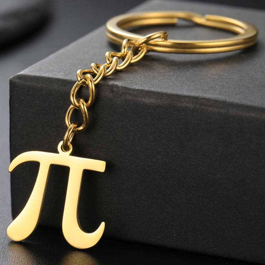 Gold keychain with pi symbol on a black surface