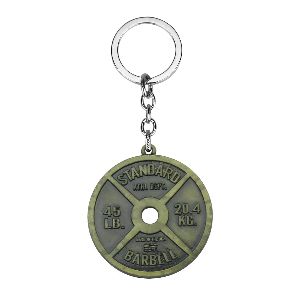 A bronze-colored keychain featuring a miniature 45 lb. plate design with 'STANDARD ATHLETIC DEPT. 45 LB' inscribed on it.
