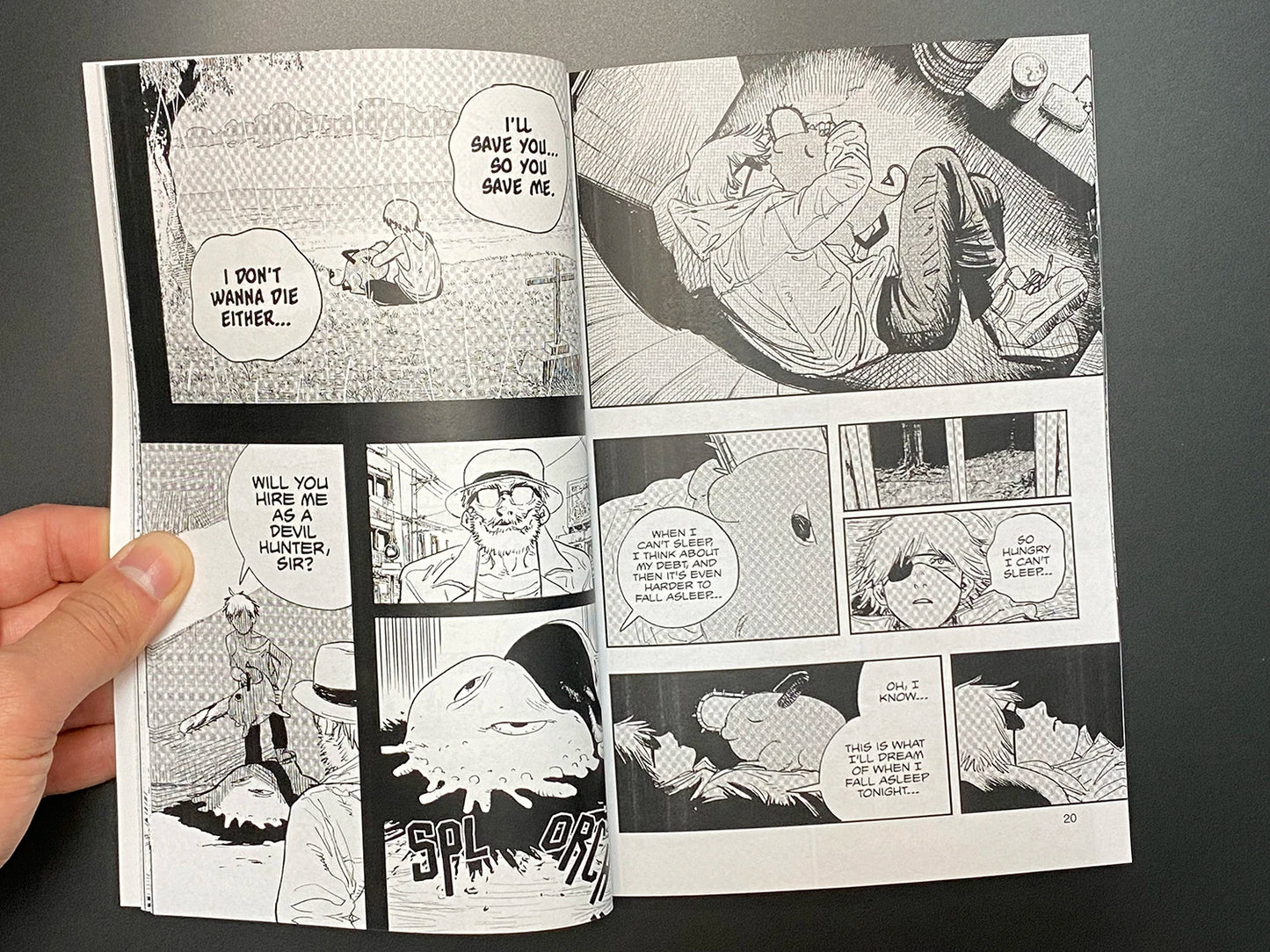 Comic book open to a page with black and white illustrations and text bubbles.