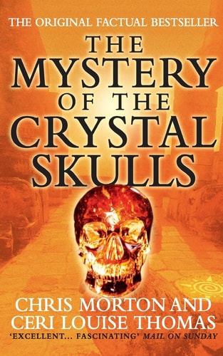 Book cover of 'The Mystery of the Crystal Skulls' with a glowing crystal skull on an orange background.