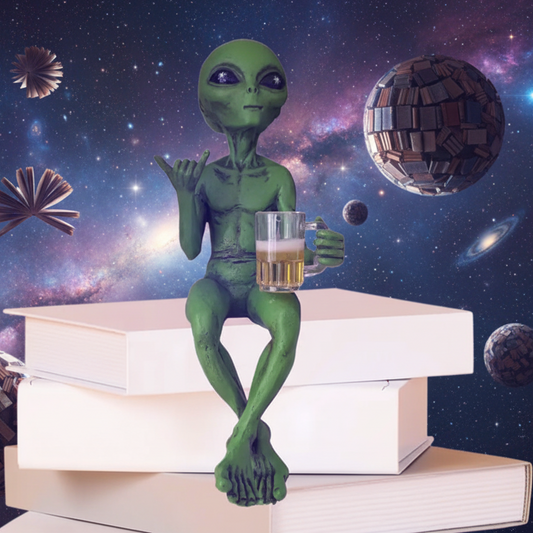 Green alien figurine holding a mug of beer with his left hand and the shaka "hang-10" sign with his right hand sitting on a stack of books with his legs crossed with a supernatural cosmic background where the planets are made of books.