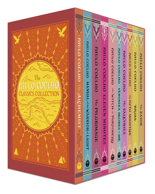 A box set of Paulo Coelho books with various titles displayed on the spines, including 'The Alchemist' and 'The Pilgrimage'. The box is primarily orange and red with a mountain design and the author's name.