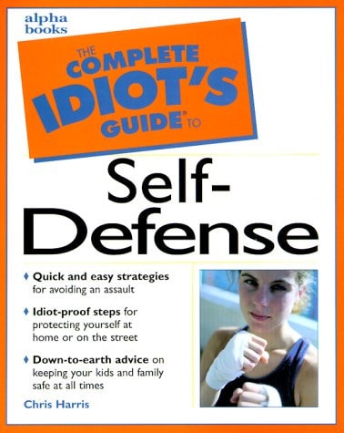 Book cover of 'The Complete Idiot's Guide to Self-Defense' with a woman in a protective glove on an orange background.