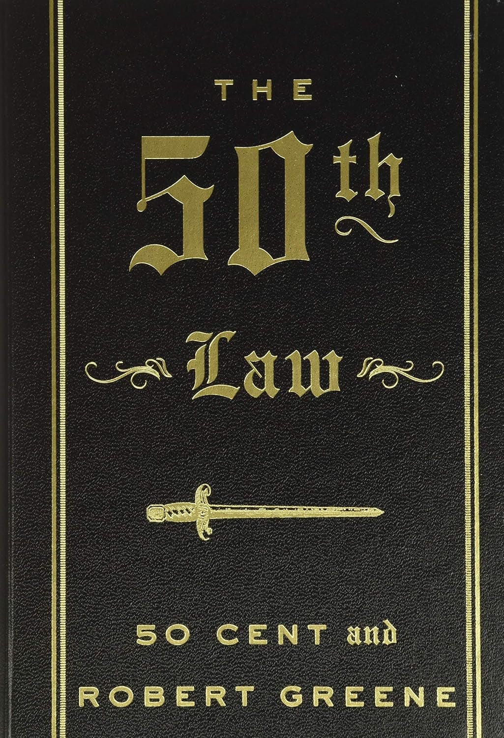 Book front cover of 'The 50th Law' by 50 Cent and Robert Greene, featuring dark background with gold text and a sword illustration.