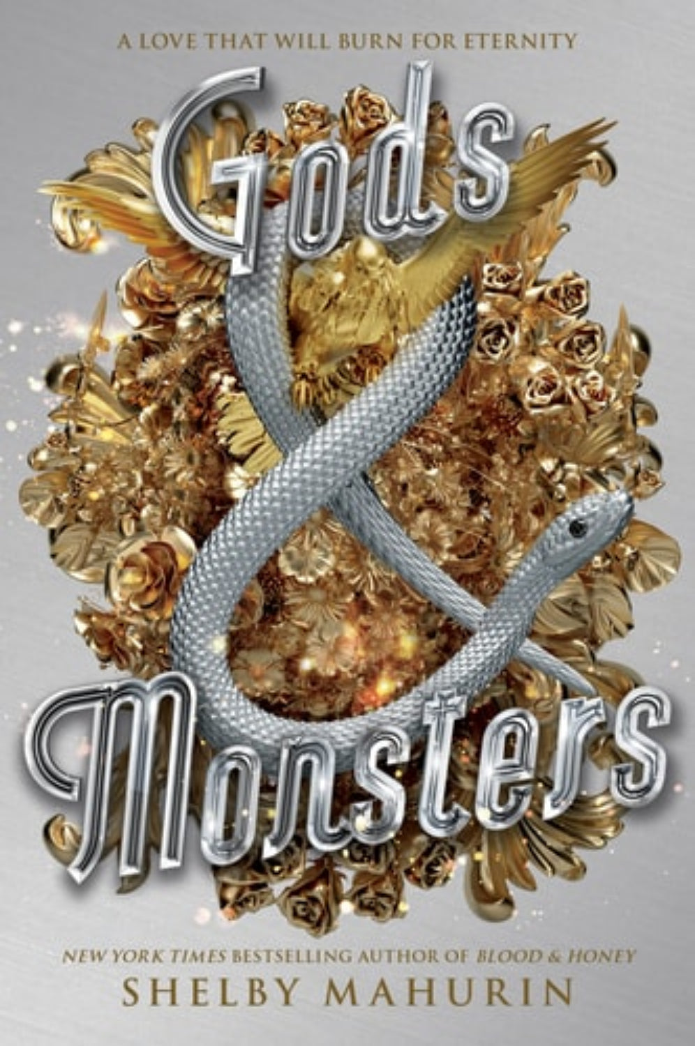Book cover of 'Gods & Monsters' by Shelby Mahurin with a silver snake and gold roses on a gray background