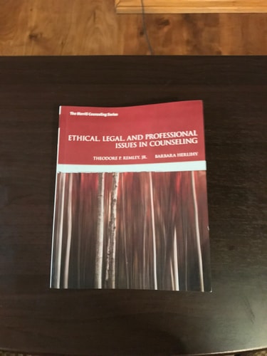 Book titled 'Ethical, Legal, and Professional Issues in Counseling' on a wooden surface