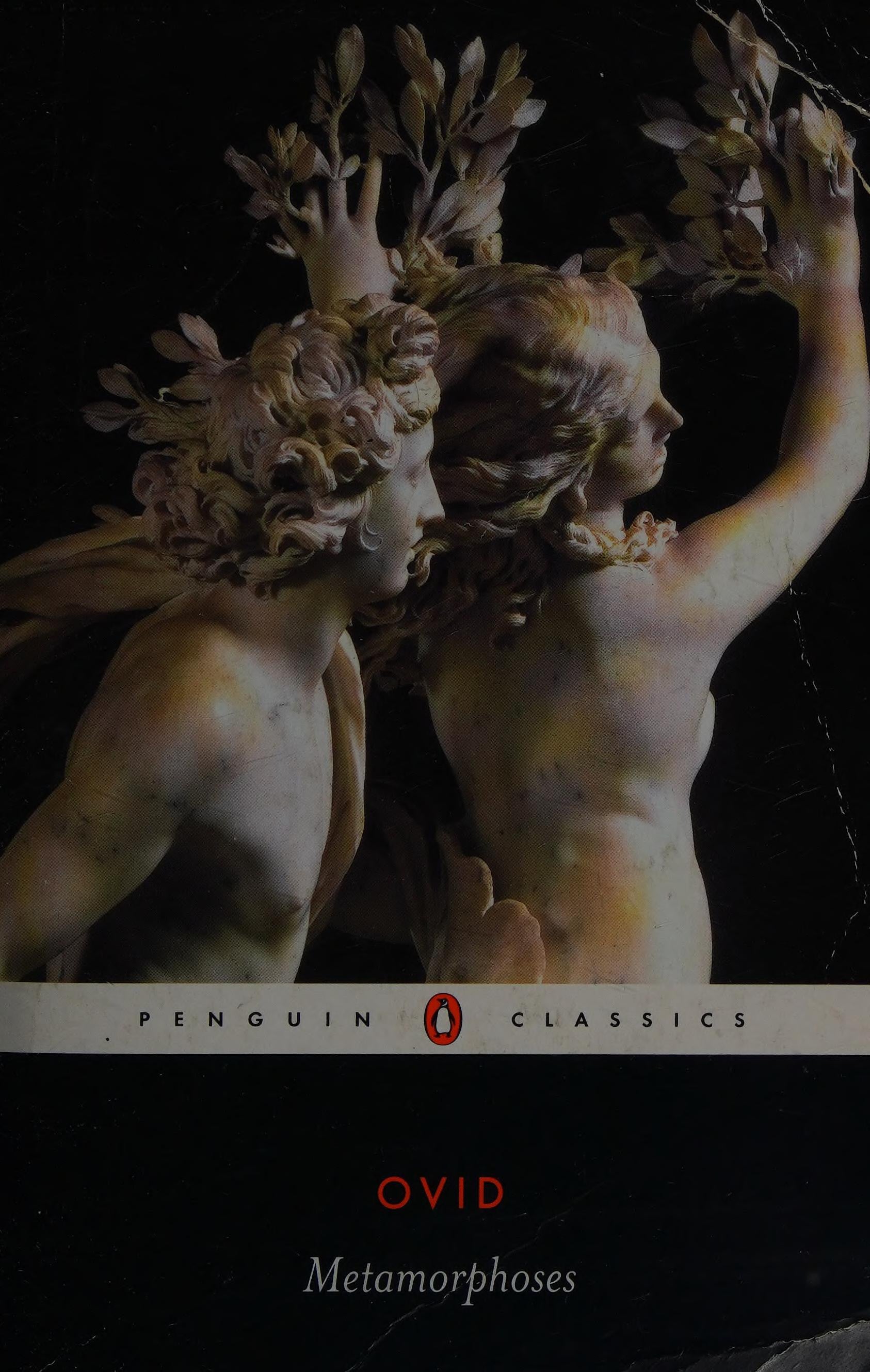 Penguin Classics edition of Ovid's Metamorphoses book cover, featuring a classical sculpture of two figures against a dark background with the title and author text at the bottom.