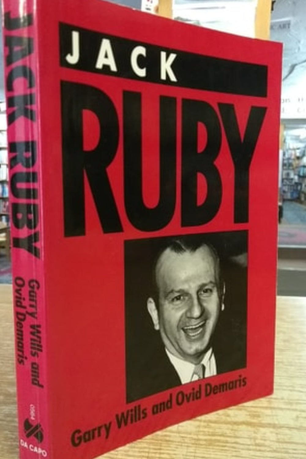 Book titled 'Jack Ruby [ISBN: 9780306805646]' with a red cover and black text, featuring a portrait of a man on a wooden surface.
