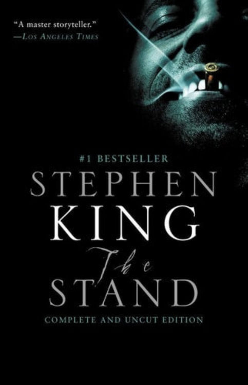 Book cover of 'The Stand' by Stephen King with a close-up of a face with a burning eye, under a dark, clouded sky.
