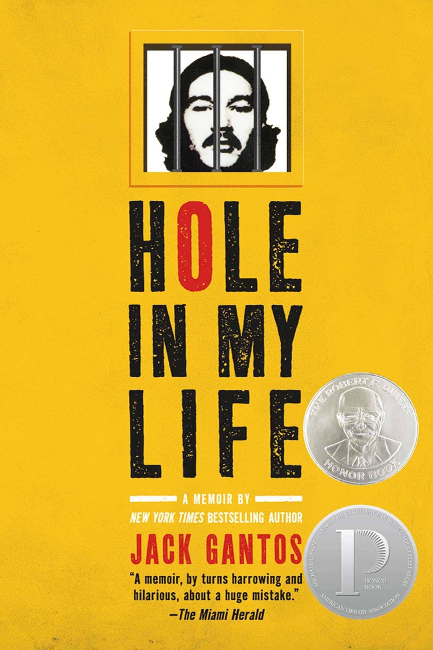 Book cover of 'Hole in My Life' by Jack Gantos, featuring a bright yellow background, large distressed black title text with one red 'O', a black-and-white portrait illustration at the top, and two silver award seals on the lower right.