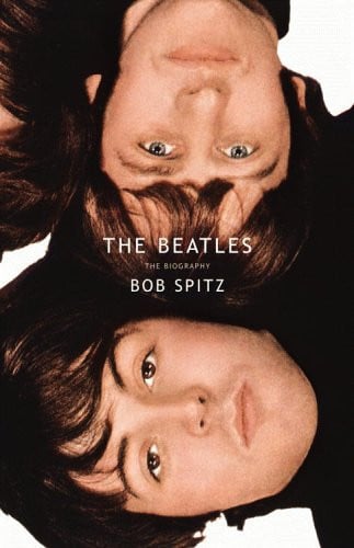Book cover for 'The Beatles: The Biography' by Bob Spitz, featuring a close-up photograph of the band members upside down against a white background with white title text.