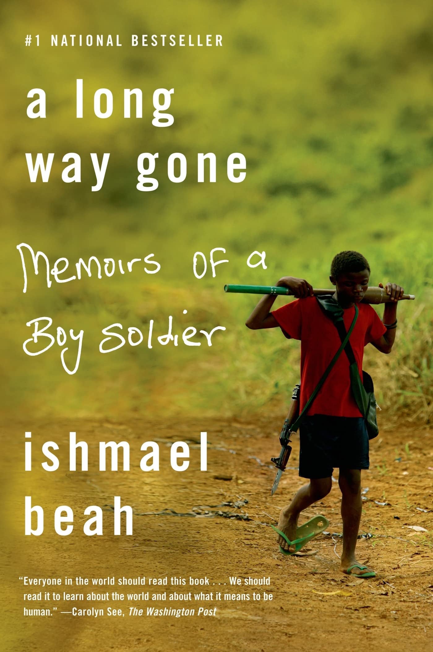 Book cover of 'A Long Way Gone: Memoirs of a Boy Soldier' by Ishmael Beah with a person carrying a rifle on a dirt path.