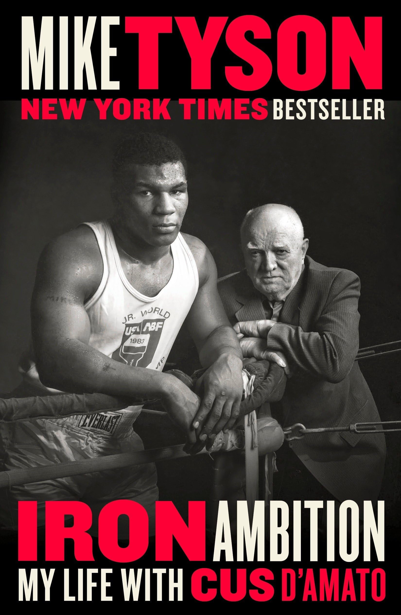 Book cover of 'Iron Ambition: My Life with Cus D'Amato' by Mike Tyson featuring a black and white photo of a boxer and an older man.