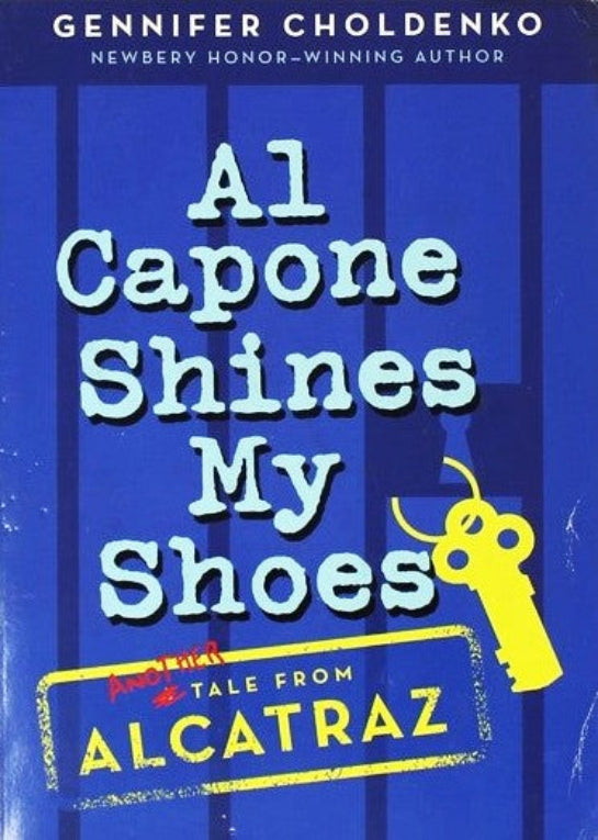 Book cover of 'Al Capone Shines My Shoes'  by Gennifer Choldenko, with a blue background and yellow gun illustration, and cartoon jail bars and keys.