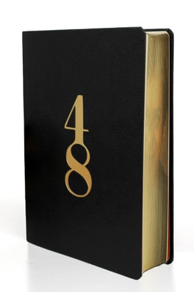 Angled book view of Book "48 Laws of Power" by Robert Greene, special Deluxe edition (ISBN: 9780593512296) with black leather cover and gilded edge pages