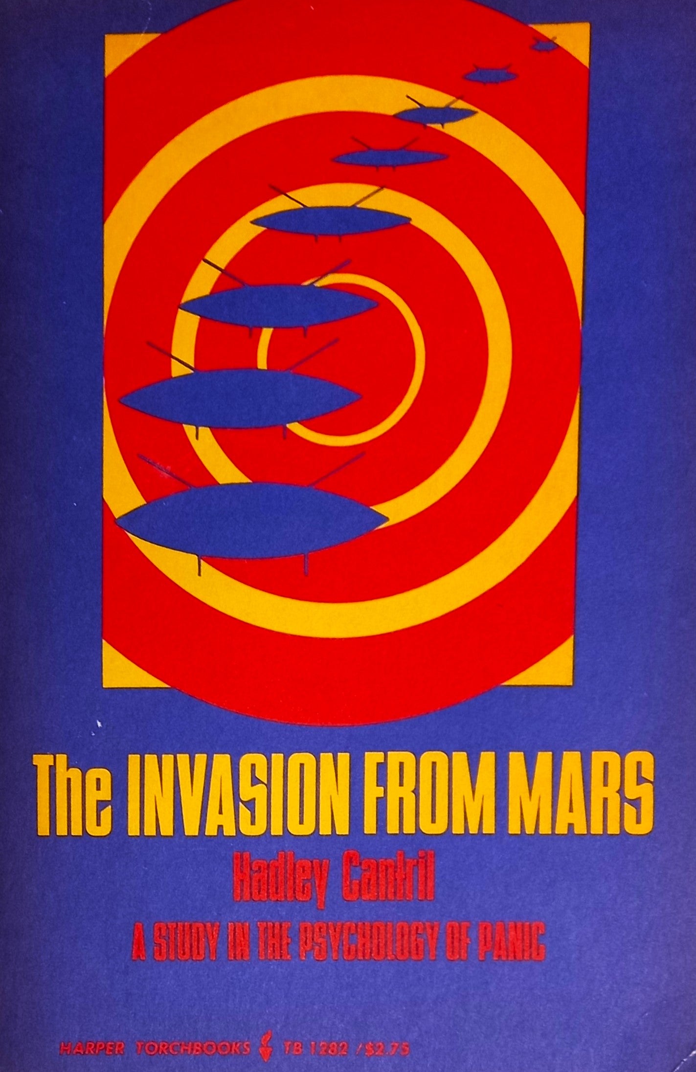 The image features the cover of "The Invasion from Mars: A Study in the Psychology of Panic" by Hadley Cantril. The cover design is striking with its vibrant colors and bold graphics.