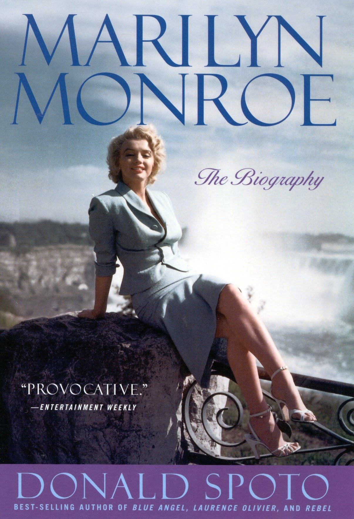 Book cover of 'Marilyn Monroe: The Biography' by Donald Spoto with a photo of Marilyn Monroe sitting on a rock.