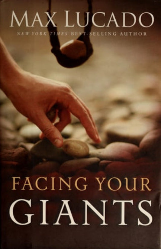 Book cover of 'Facing Your Giants' by Max Lucado with a hand reaching towards stones.