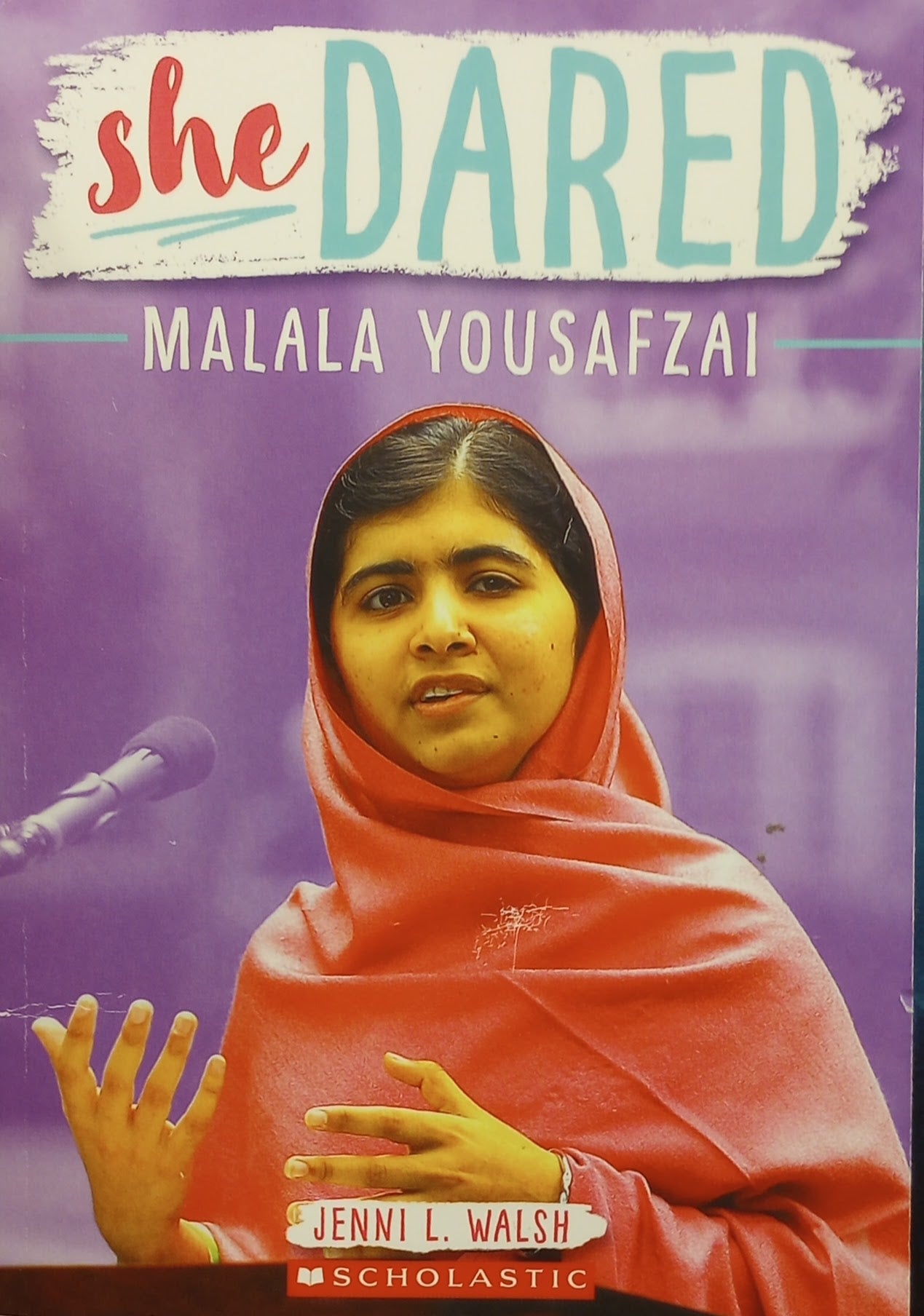 Book cover of 'She Dared: Malala Yousafzai' by Jenni Walsh (ISBN: 9781338550818) with a photo of Malala Yousafzai in red over a purple background