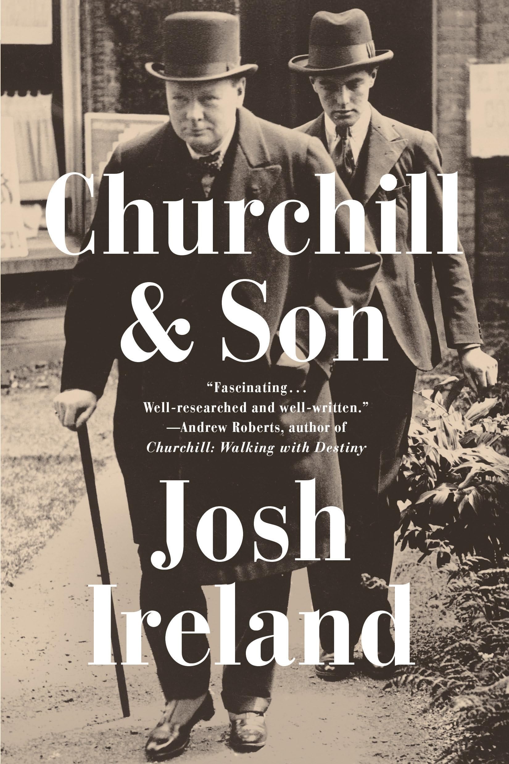 Book cover of 'Churchill & Son' by Josh Ireland featuring a black and white photo of two men walking.
