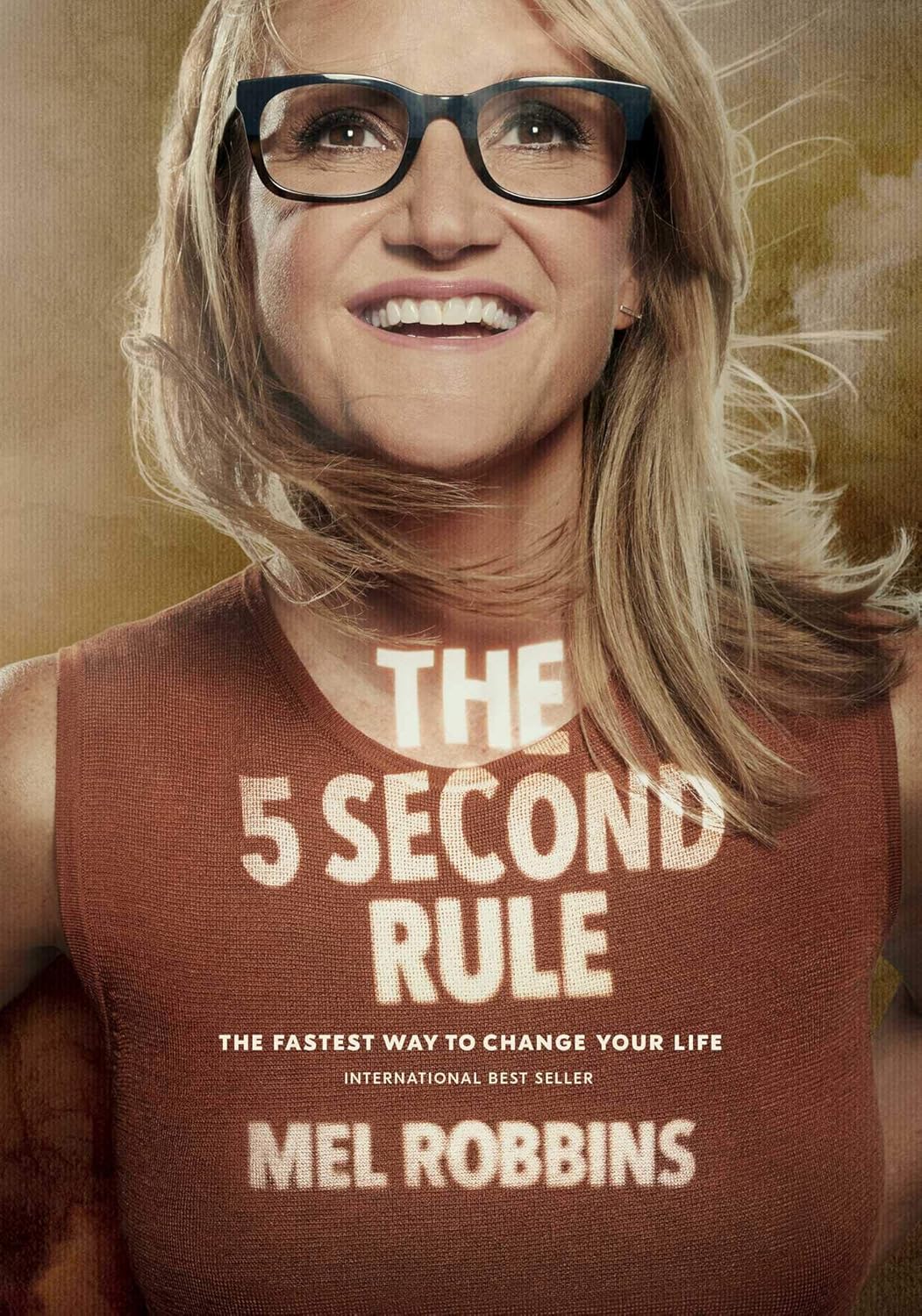 Promotional image of a book titled 'The 5 Second Rule' by Mel Robbins with a person wearing glasses and a brown tank top.